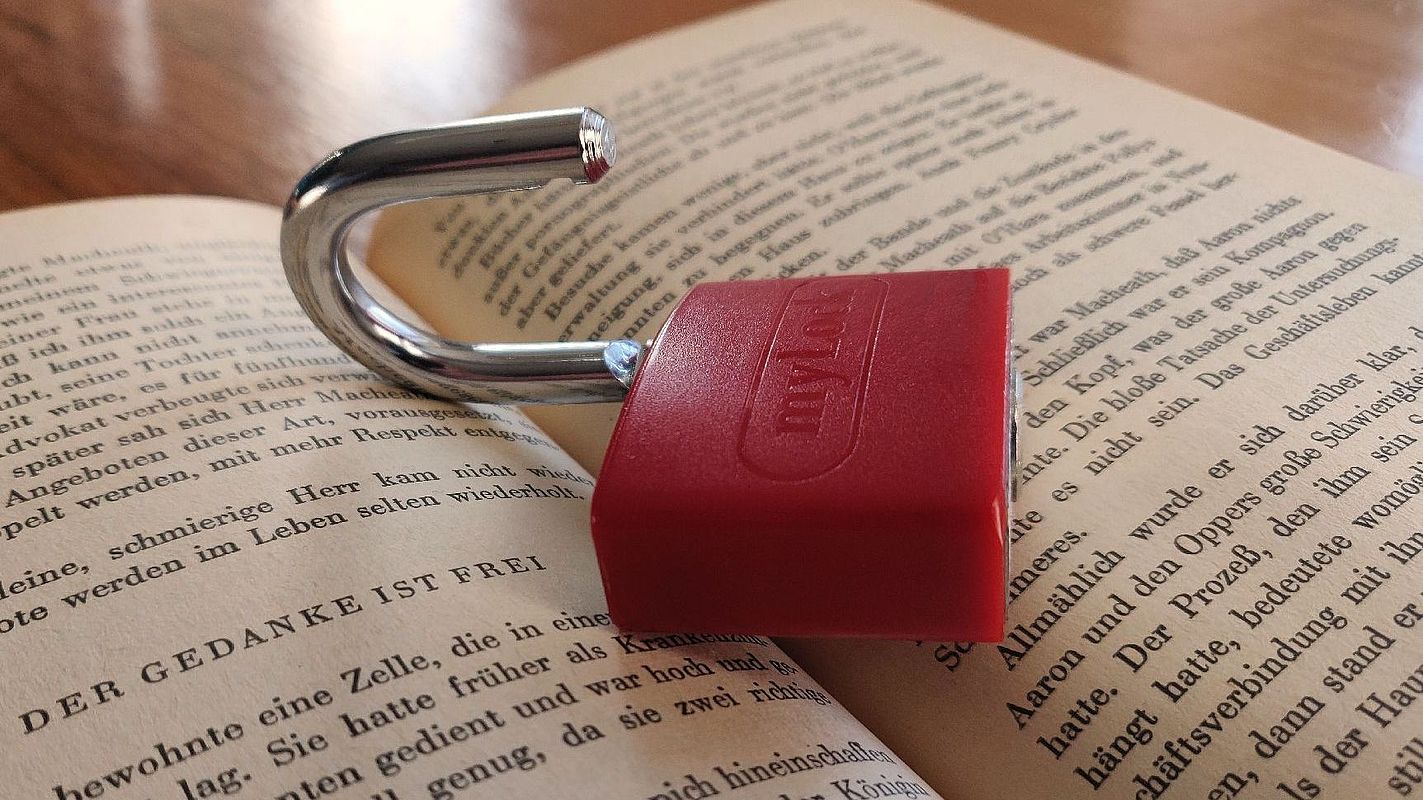 Open padlock on book pages