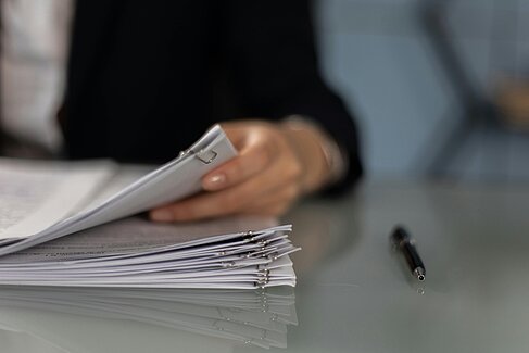 Person, die Papierakten durchsucht.  Bild unter Lizenz Pexels