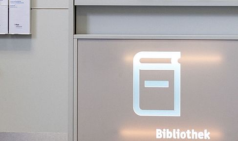 Bibliothekstheke mit erleuteten Bibliothekslogo darauf