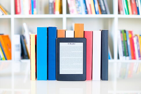 E-Book leans against books